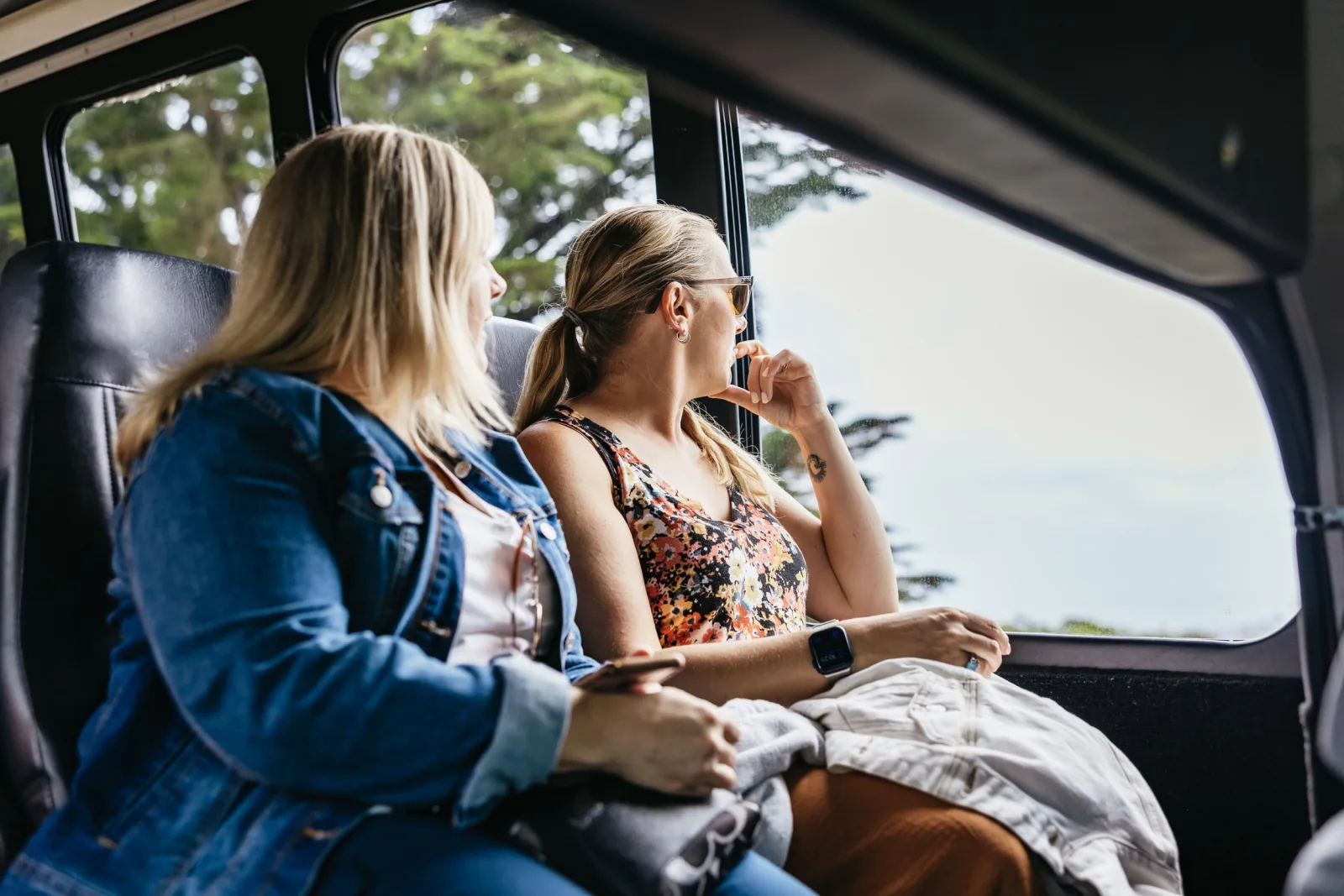Guests relaxing and looking out the window aboard the tour coach