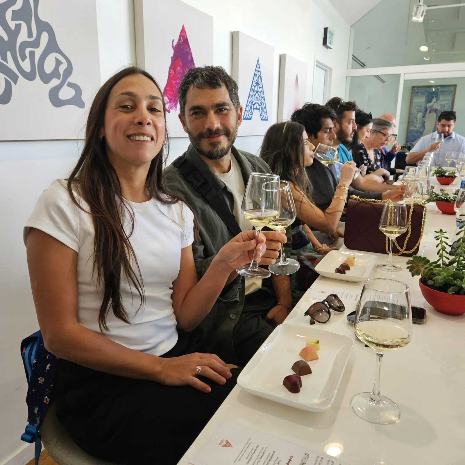 Wine tasting group toasting with white wine at a tasting room table
