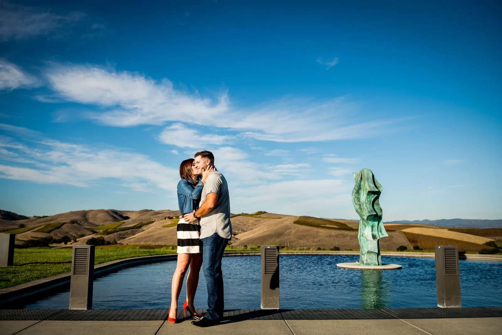 Couple sharing a moment beside a reflecting pool at a Napa Valley winery