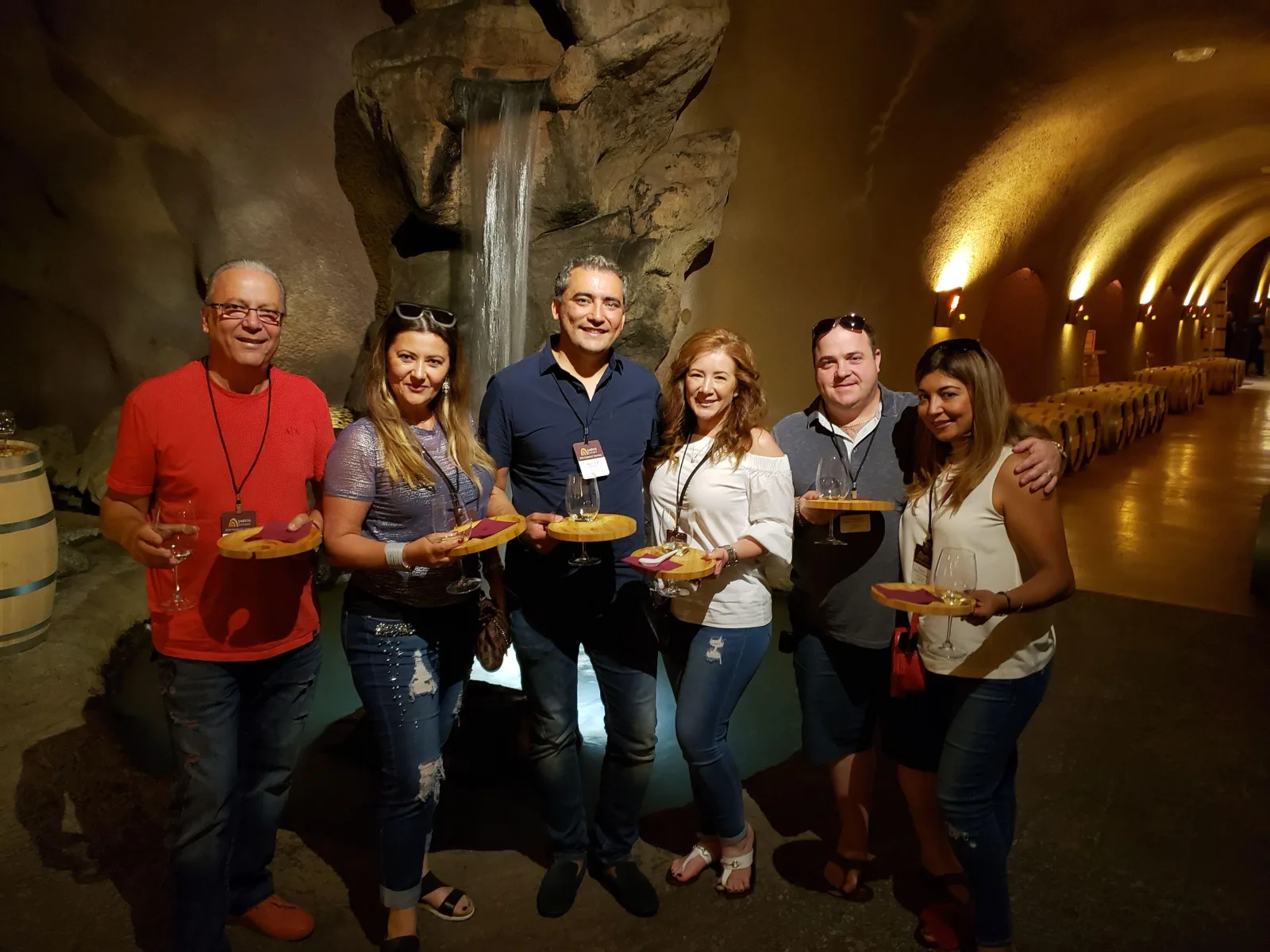 Private group tasting wine inside a Napa Valley wine cave with a stone waterfall