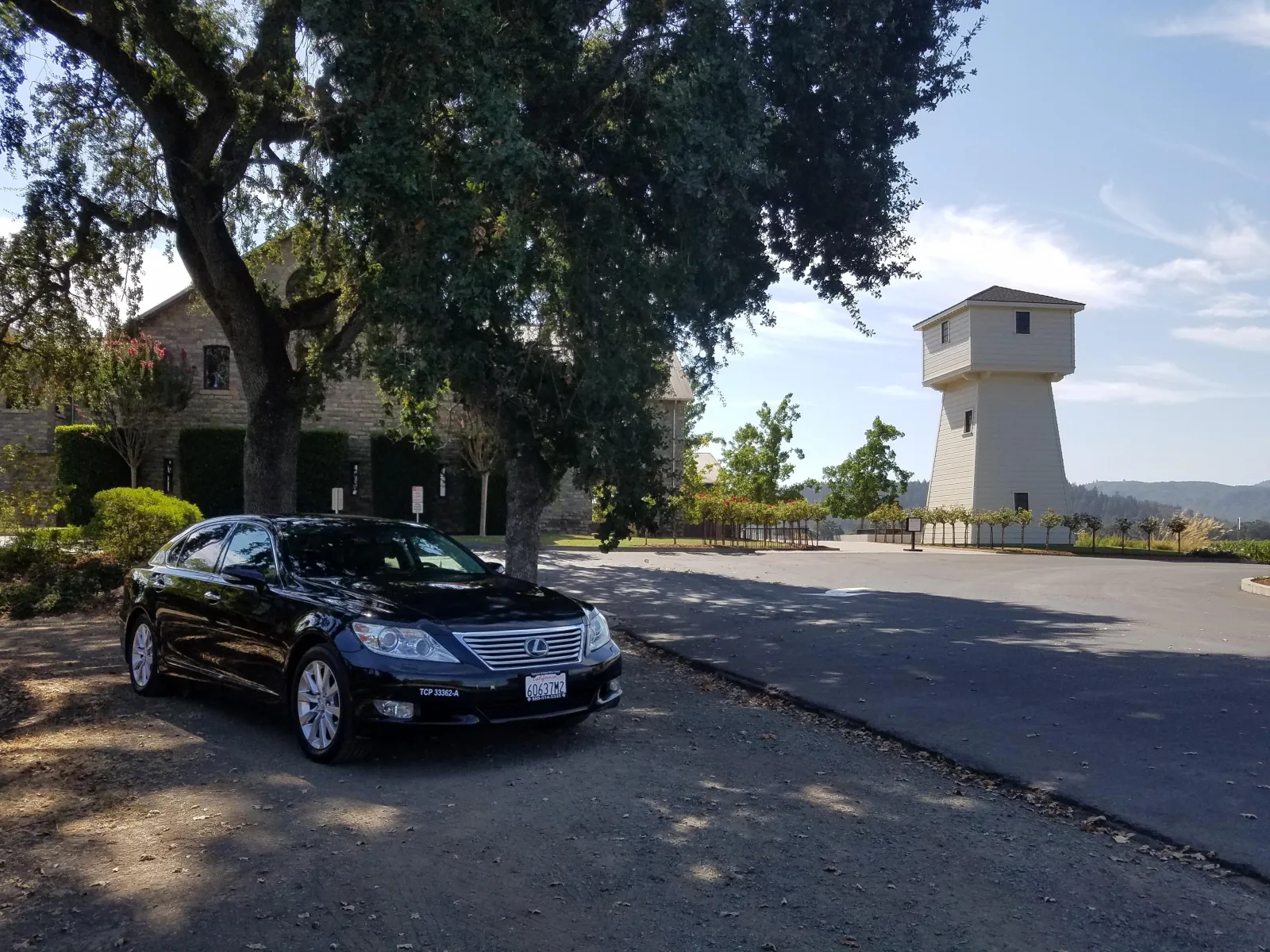 Private chauffeured sedan parked outside a Napa Valley winery estate